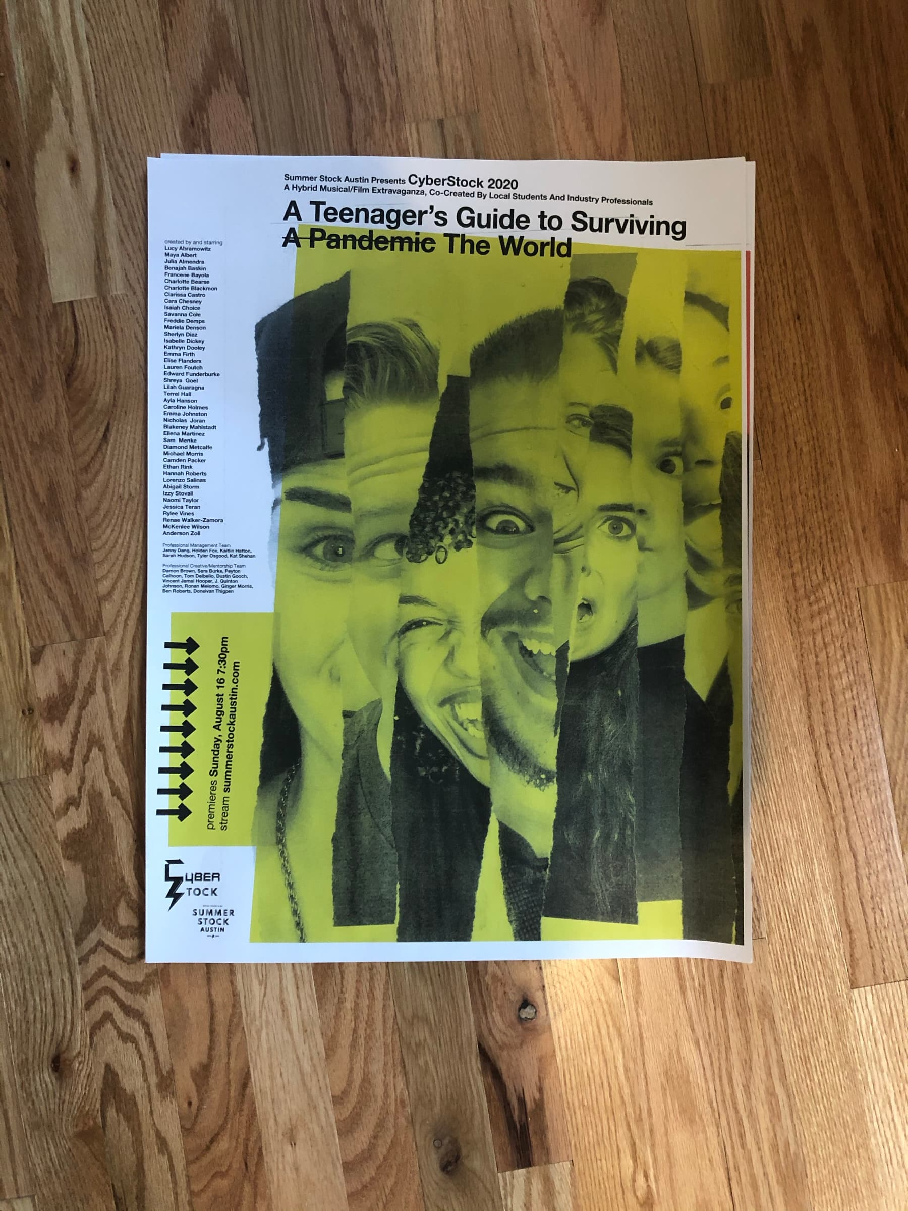 A printed Cyberstock poster lying on a wood floor in yellow halftone: cast headshots arranged across the sheet.