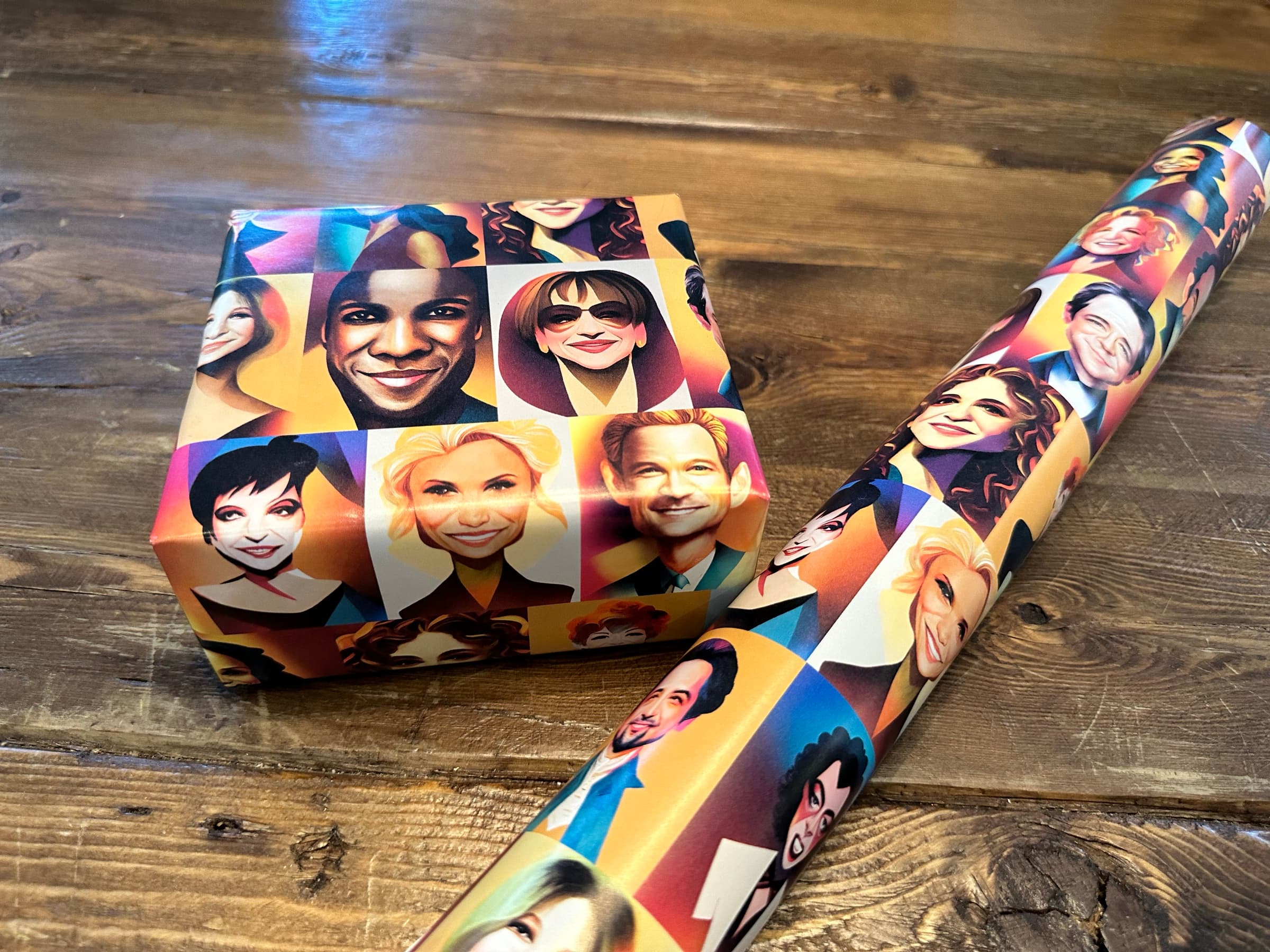 A flatter overhead view of both objects together: a wrapped present on the left, a partially unrolled tube of the portrait paper on the right, and the wood grain of the floor between them, with the patterns of the paper carrying enough strength to read at the small box scale and the long roll scale alike.